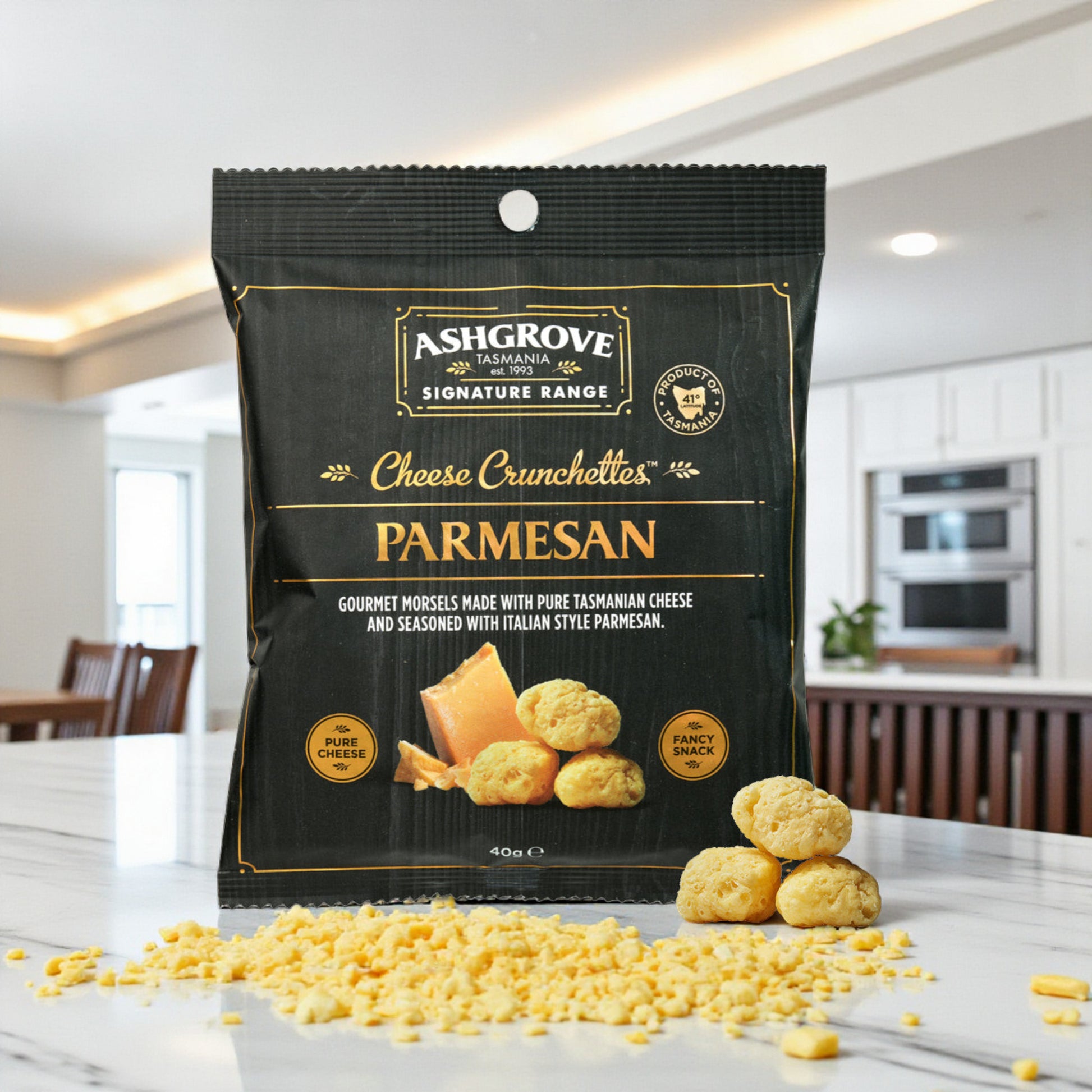 Ashgrove Cheese Tasmania Crunchettes Parmesan packaging on a kitchen counter with parmesan cheese crumbs.