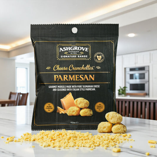 Ashgrove Cheese Tasmania Crunchettes Parmesan packaging on a kitchen counter with parmesan cheese crumbs.