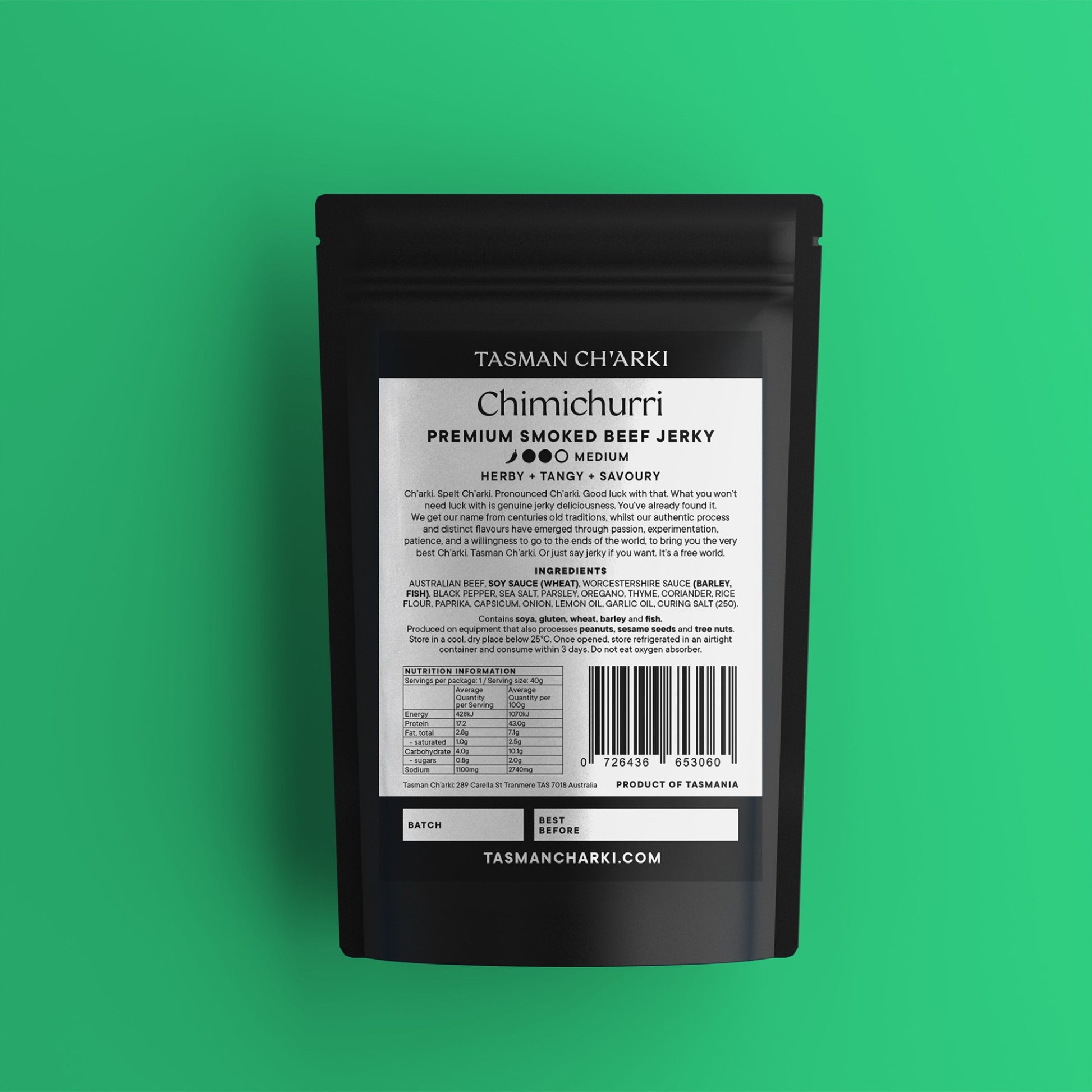 Black package of Tasmanian Tasman Ch'arki Chimichurri Premium Smoked Beef Jerky on a green background