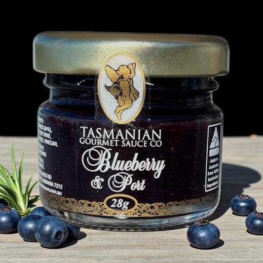 Jar of Tasmanian Gourmet Sauce Co Blueberry & Port Jam on a wooden surface with blueberries around
