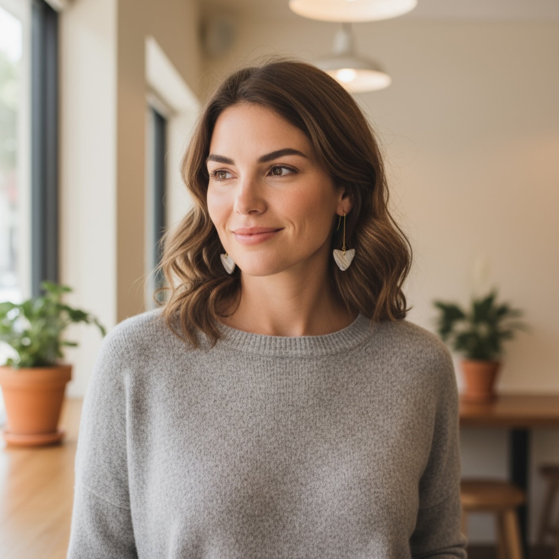 Woman wearing East Coast Tasmania-shaped drop earrings handmade from real shells by MarvLee Designs