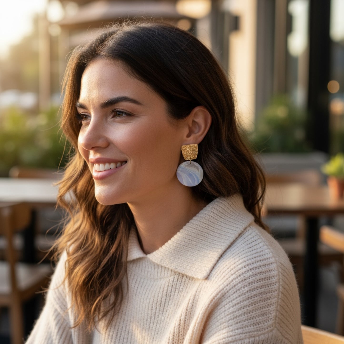 Woman wearing Reef large statement dangle earrings showing gold texture and ocean-inspired blue wave marbling by MarvLee Designs Tasmania