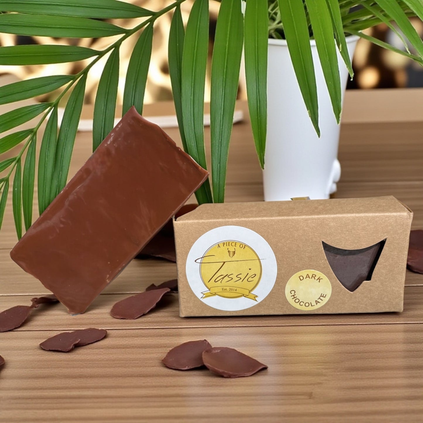 Tasmanian Dark Chocolate Fudge bar, shavings of dark chocolate with a plant in the background