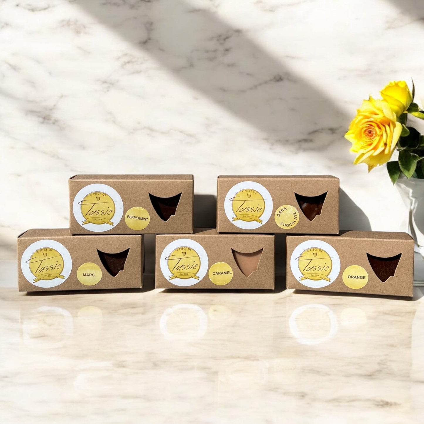 Handmade Tasmanian fudge variety pack showing five different flavors including caramel, dark chocolate, peppermint, orange and Mars caramel