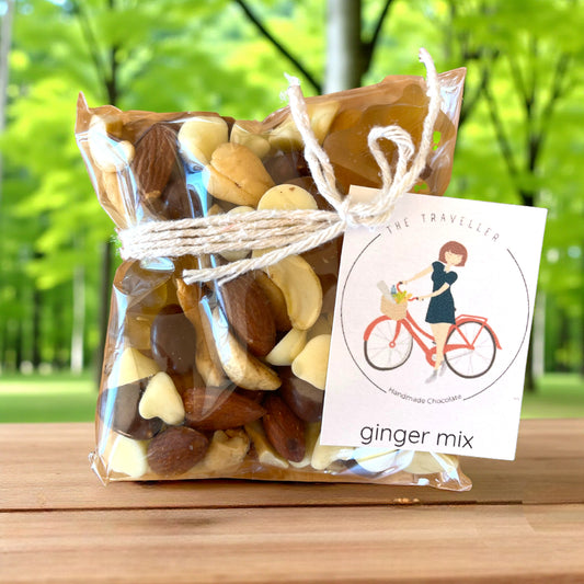 Packaged Tasmanian ginger trail mix with a label on a wooden surface and green outdoor background
