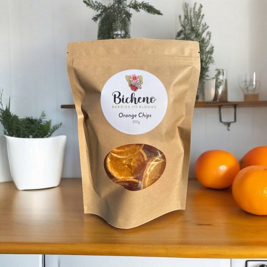 A package of Tasmanian dehydrated orange chips displayed on a kitchen counter with oranges in the background.