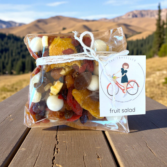 Packaged Tasmanian fruit salad trail mix on a wooden surface with a mountainous background