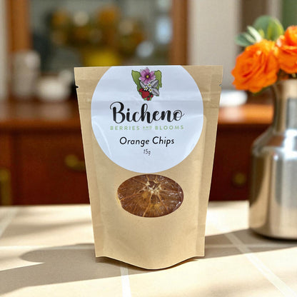 Bag of Bicheno Berries and Blooms Tasmania Orange Chips on a kitchen counter with flowers in the background