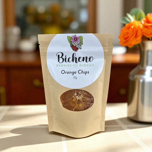 Bag of Bicheno Berries and Blooms Tasmania Orange Chips on a kitchen counter with flowers in the background