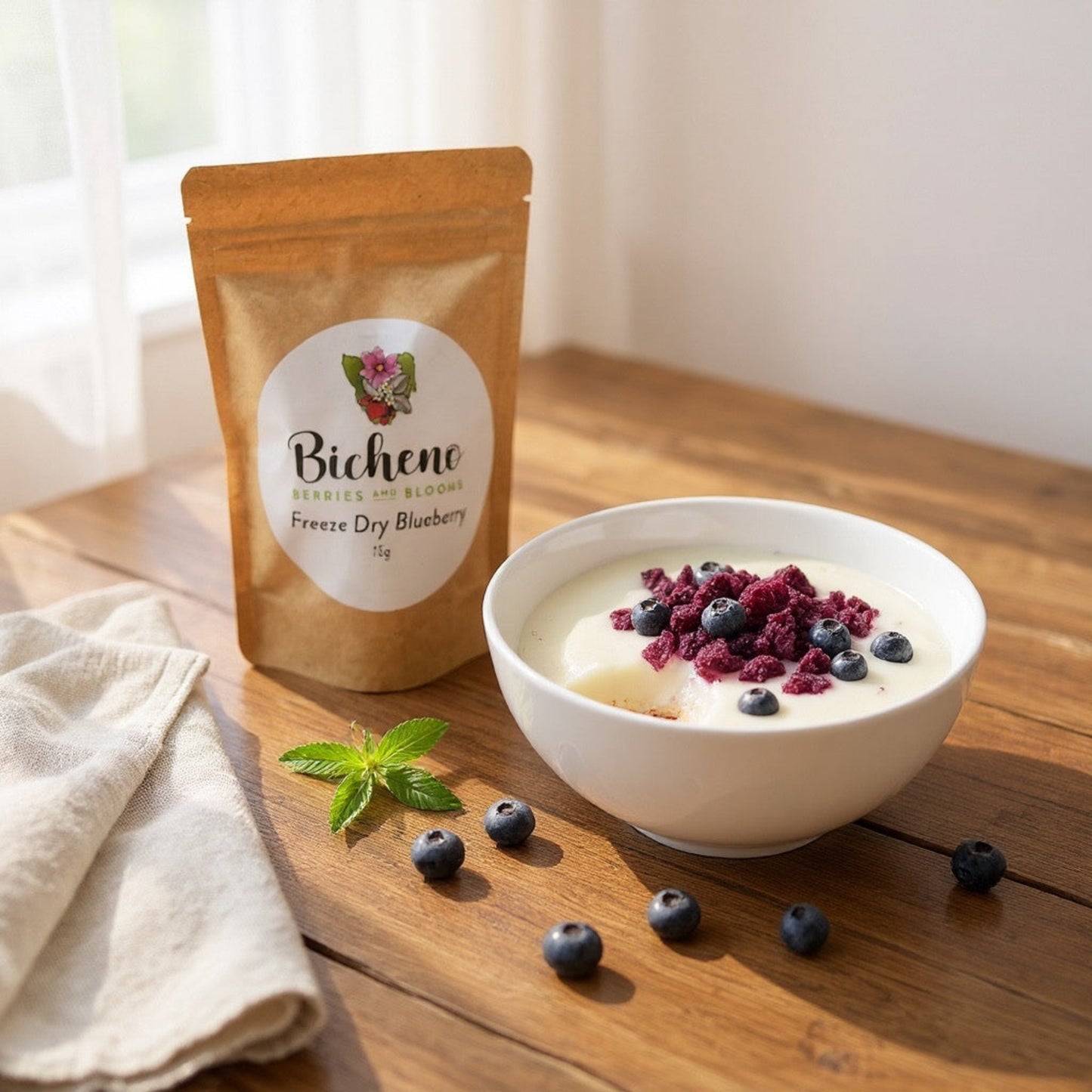 Bowl of yoghurt with freeze-dried blueberries and a package of Tasmanian Bicheno berries on a wooden surface.