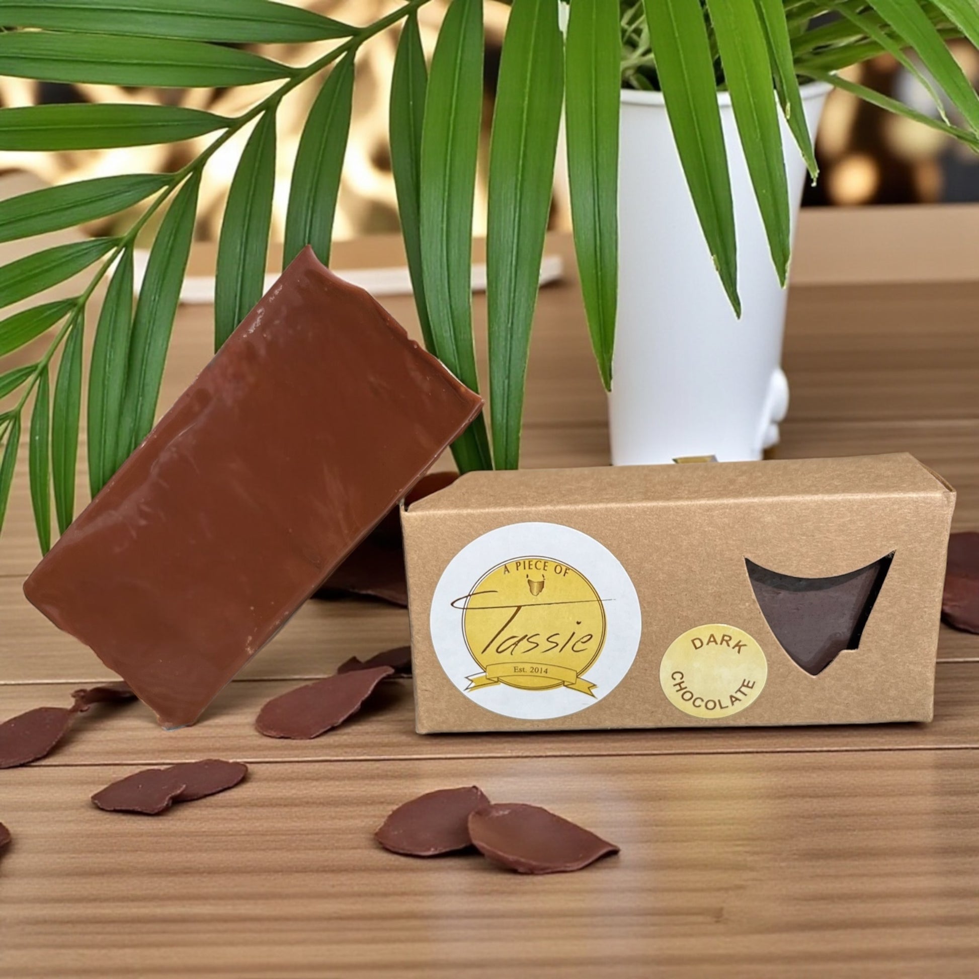 Tasmanian Dark Chocolate Fudge bar, shavings of dark chocolate with a plant in the background