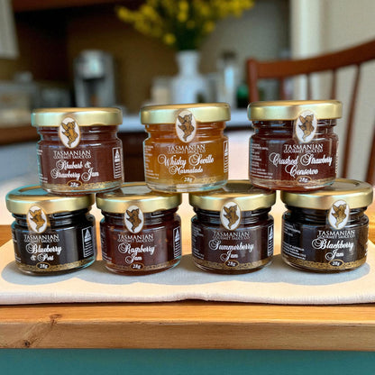 Seven pack of assorted jars of Tasmanian preserves on a kitchen counter.