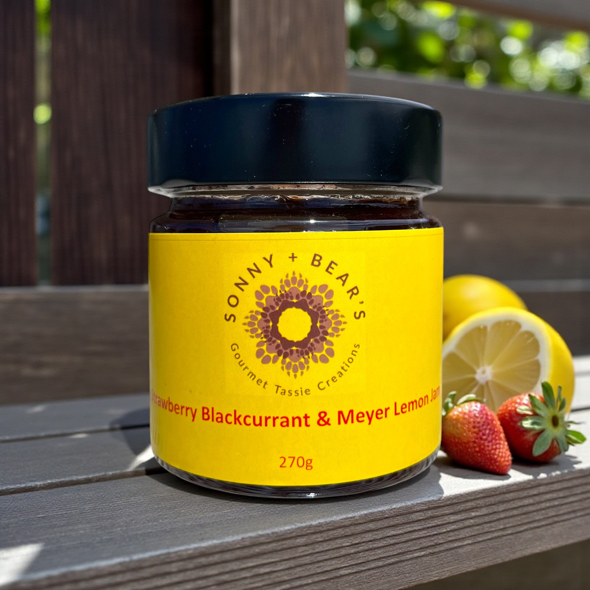 Jar of Sonny & Bear's Tasmanian Strawberry Blackcurrant & Meyer Lemon jam on a wooden surface