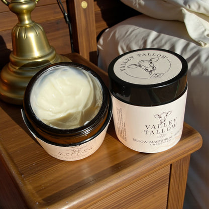 Tasmanian Valley Tallow Magnesium Lotion unscented with open lid showing rich tallow lotion texture on wooden bedside table